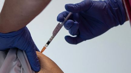 Une résidente d'un Ehpad se fait vacciner contre le Covid-19, le 7 janvier 2021 à Vannes (Morbihan). (LOIC VENANCE / AFP)