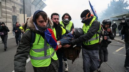 Des "gilets jaunes" portent secours à un blessé, le 5 janvier.&nbsp; (ZAKARIA ABDELKAFI / AFP)