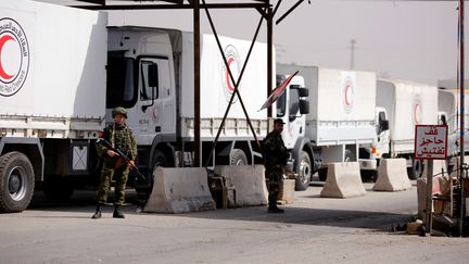 Des camions du Croissant rouge syrien, transportant de l'aide humanitaire, attendent à un checkpoint près de Damas, le 5 mars 2018. (OMAR SANADIKI / REUTERS)