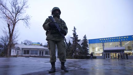 Un&nbsp;homme arm&eacute; garde l'entr&eacute;e de l'a&eacute;roport de Simferopol, en Crim&eacute;e (Ukraine), le 28 f&eacute;vrier 2014. (IVAN SEKRETAREV / AP / SIPA )