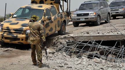 Un soldat &nbsp;fait la circulation sur un pont que&nbsp;Boko Haram est soup&ccedil;onn&eacute; d'avoir d&eacute;truit, le 11 mai 2014 &agrave; Ngala, dans le nord-est du Nigeria. ( AFP / PHOTNONSTOP)