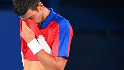 Novak Djokovic voit ses rêves d'or olympique s'envoler, le 30 juillet 2021 à Tokyo. (VINCENZO PINTO / AFP)