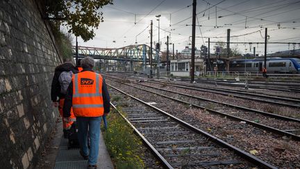 Des employés de la SNCF marchent le long&nbsp;des&nbsp;rails à Vierzon (Cher), le 18 novembre 2016 (photo d'illustration). (GUILLAUME SOUVANT / AFP)