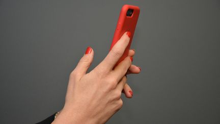 Une femme consulte son smartphone et ses SMS. (JEAN-CHRISTOPHE BOURDILLAT / RADIO FRANCE)