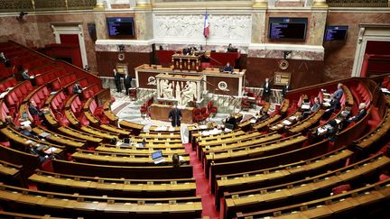 En effectfs réduits en raison de l'épidémie, les députés examinent le projet de loi d'urgence contre le Covid-19, le 21 mars 2020, à l'Assemblée nationale, à Paris. (LUDOVIC MARIN / AFP)