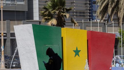 The silhouette of a police officer in front of a fountain decorated with the motif of the Senegalese national flag, in Dakar, Senegal, February 14, 2024. (JEROME FAVRE / MAXPPP)