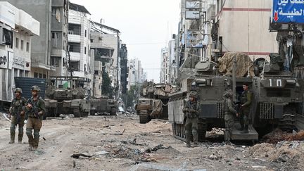 Les troupes israéliennes patrouillent dans une rue lors d'une opération militaire dans le nord de la bande de Gaza, le 22 novembre 2023. (AHIKAM SERI / AFP)