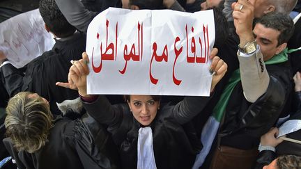 "La défense avec le citoyen", les avocats ont rejoint la protestation le 25 février 2019, ici devant le tribunal de Sidi M’hamed à Alger. Les avocats ont appellent au respect de la Constitution. (RYAD KRAMDI / AFP)