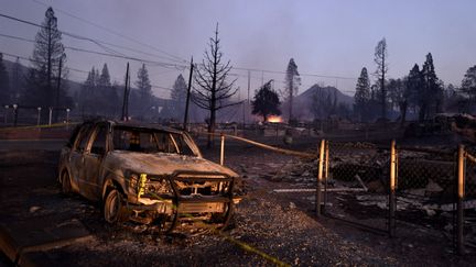 Des maisons et une voiture détruites par le "Mill Fire" dans le nord de Weed, en Californie, le 2 septembre 2022. (NEAL WATERS / ANADOLU AGENCY / AFP)
