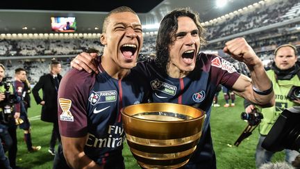 Premier trophée pour Kylian Mbappé, qui célèbre avec Edinson Cavani - passation de relais entre le jeune attaquant et celui qui est alors le meilleur buteur de l'histoire du PSG -, lors de la finale de la Coupe de la Ligue contre Monaco, le 31 mars 2018. (UGO AMEZ/SIPA)