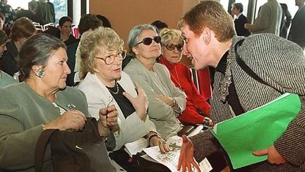 La députée Khalida Messaoudi (debout) s'entretient avec les anciennes ministres Simone Veil (à gauche) et Yvette Roudy, le 9 mars 2000 à Alger, lors d'une réunion publique organisée par les féministes algériennes sous le thème «Alger, capitale-symbole de la résistance des femmes». (HZ / AFP)