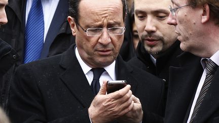 Fran&ccedil;ois Hollande consulte son t&eacute;l&eacute;phone portable, le 27 avril 2012, lors d'une visite au festival du Printemps de&nbsp;Bourges (Cher). (JACKY NAEGELEN / REUTERS)