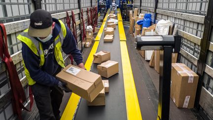 Un employé de La Poste au centre de tri des colis de Toulouse Fondeyre (Haute-Garonne), le 12 novembre 2020. (FR?D?RIC SCHEIBER / HANS LUCAS / AFP)