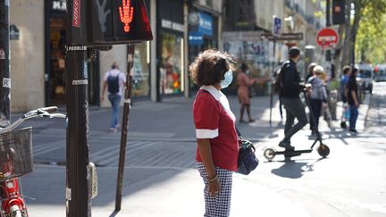 Une habitante de Paris portant le masque dans une rue de la capitale, le 12 septembre 2020. (MYRIAM TIRLER / HANS LUCAS / AFP)