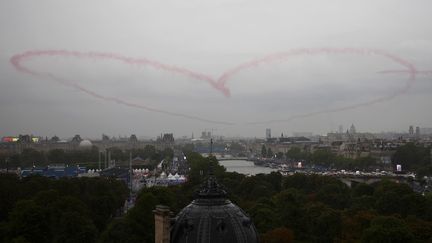 Paris, ville de l'amour... Quatre avions de la patrouille de France ont formé un coeur dans le ciel parisien. (ANNE-CHRISTINE POUJOULAT / AFP)