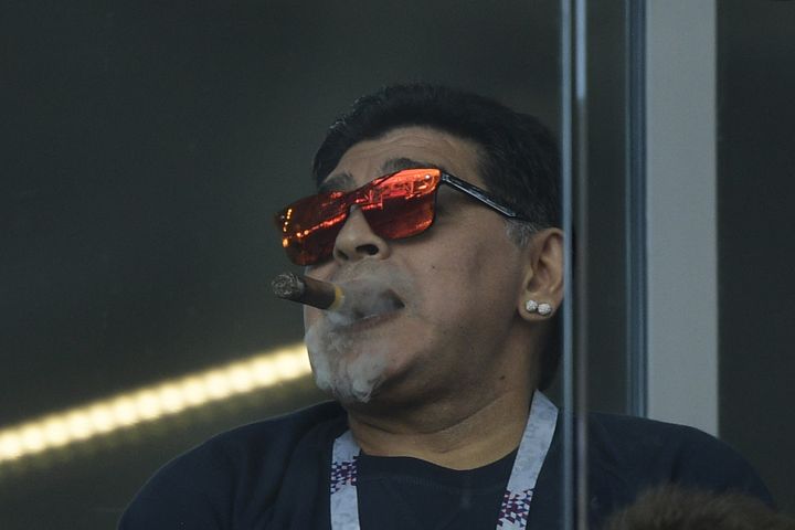 Diego Maradona savoure un cigare dans une tribune non-fumeur du stade du Spartak Moscou, le 16 juin 2018 lors du match Argentine-Islande. (JUAN MABROMATA / AFP)