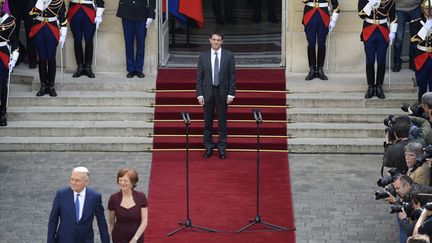 Le nouveau Premier ministre Manuel Valls&nbsp;(C) regarde son pr&eacute;d&eacute;cesseur Jean-Marc Ayrault et son &eacute;pouse quitter l'h&ocirc;tel Matignon &agrave; Paris, le 1er avril 2014. (LIONEL BONAVENTURE / AFP)