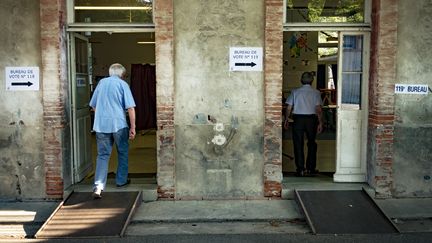 Deux électeurs entrent dans un bureau de vote, à Toulouse (Haute-Garonne), pour le premier tour des élections législatives, le 11 juin 2017. (ERIC CABANIS / AFP)