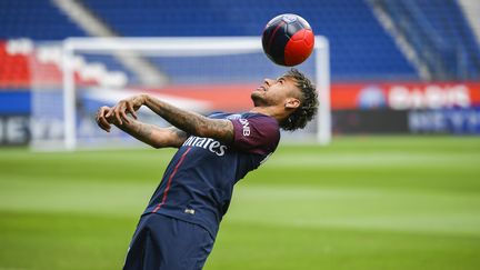 Le Parisien Neymar jongle sur la pelouse du Parc des Princes vendredi 4 août après sa présentation à la presse. (LIONEL BONAVENTURE / AFP)