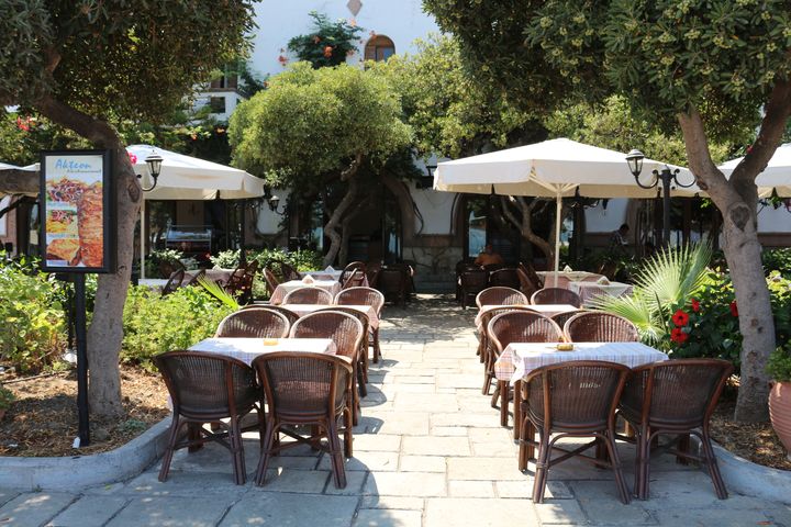 La terrasse vide du caf&eacute; o&ugrave; travaille Kosta, &agrave; c&ocirc;t&eacute; du poste de police de Kos (Gr&egrave;ce) o&ugrave; des centaines de migrants attendent chaque jour de se faire enregistrer, le 20 ao&ucirc;t 2015. (BENOIT ZAGDOUN / FRANCETV INFO)