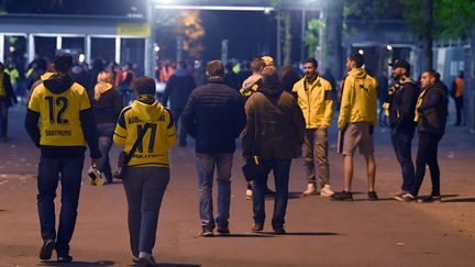 Des fans du Borussia Dortmund quittent le stade après le report du quart de finale aller de la Ligue des champions contre Monaco, le 11 avril 2017. (FEDERICO GAMBARINI / AFP)