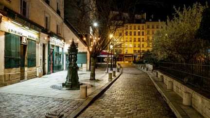 Une rue vide à Paris, le 15 décembre 2020, au premier soir du couvre-feu national. (HAMID AZMOUN / HANS LUCAS / AFP)