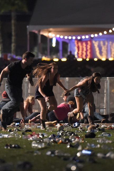 Des gens s'enfuient et tentent de se protéger, lors de la fusillade survenue à Las Vegas, le 1er octobre 2017 (DAVID BECKER / GETTY IMAGES NORTH AMERICA / AFP)