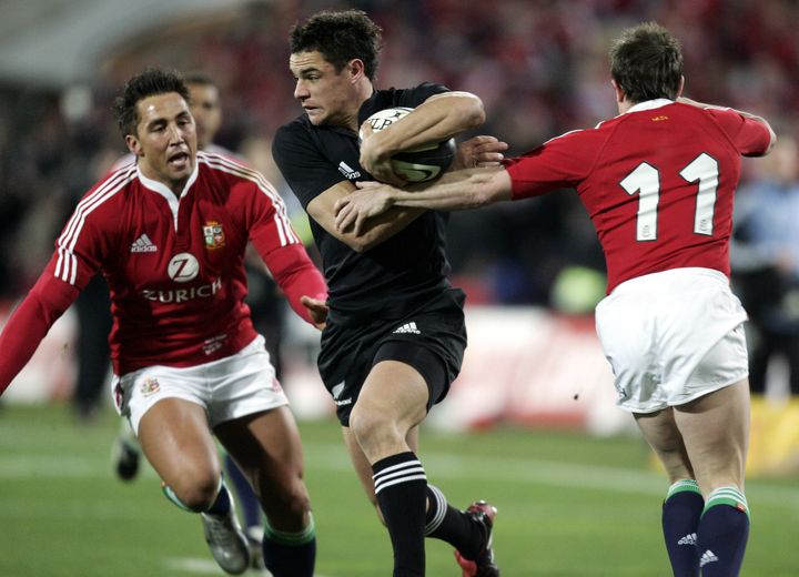 Le joueur All Black Dan Carter échappe au plaquage de deux adversaires lors du match de son équipe face aux Lions Britanniques, le 2 juillet 2005 à Christchurch (Nouvelle-Zélande). (ANTHONY PHELPS / REUTERS)