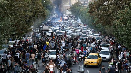 Des personnes manifestent à Téhéran, en Iran, le 21 septembre 2022, après la mort suspecte de Mahsa Amini.&nbsp; (STRINGER / ANADOLU AGENCY / AFP)