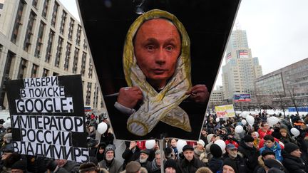 Une pancarte arbor&eacute;e par des manifestants &agrave; Moscou, le 24 d&eacute;cembre 2011. Elle repr&eacute;sente Vladimir Poutine, habill&eacute; d'un pr&eacute;servatif. (KADOBNOV AFP PHOTO / KIRILL KUDRYAVTSEV / AFP)