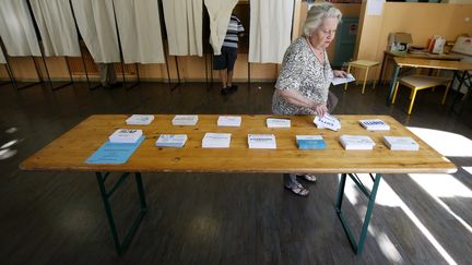 Une femme prend les bulletins avant d'aller voter&nbsp;pour le premier tour des législatives,&nbsp;le 11 juin 2017 au Touquet. (MAXPPP)