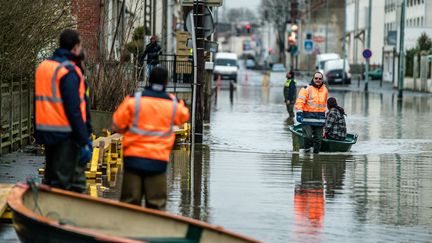 Des employés municipaux aident les habitants de Villeneuve-Saint-Georges (Val-de-Marne), après les crues de la Seine et de l'Yerres, le 26 janvier 2018.&nbsp; (SIMON GUILLEMIN / HANS LUCAS / AFP)