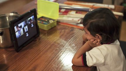 Un enfant devant une tablette, à Mexico, le 24 août 2020. (JULIO CESAR AGUILAR / AFP)