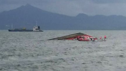 Des secouristes entourent la partie &eacute;merg&eacute;e de la coque du "Kim Nirvana", un ferry qui a fait naufrage dans le centre des Philippines, jeudi 2 juillet 2015. ( AFP )