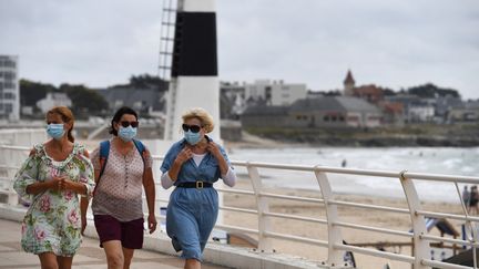 Des femmes se baladent&nbsp;masquées à Quiberon (Morbihan), le 27 juillet 2020.&nbsp; (FRED TANNEAU / AFP)