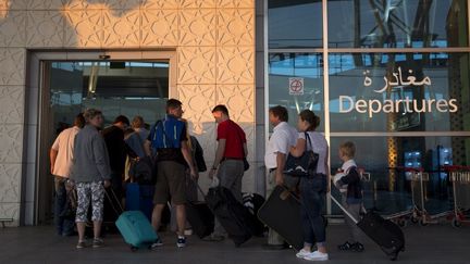 Des touristes s'appr&ecirc;tent &agrave; embarquer &agrave; l'a&eacute;roport d'Enfidha, pour quitter la Tunisie.&nbsp; (KENZO TRIBOUILLARD / AFP)