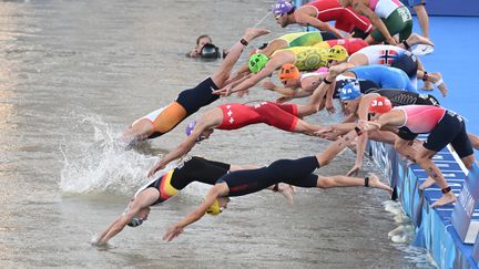 Les triathlètes plongent dans la Seine lors de l'épreuve de relais mixte aux Jeux olympiques, le 5 août 2024. (MARIJAN MURAT / DPA / AFP)