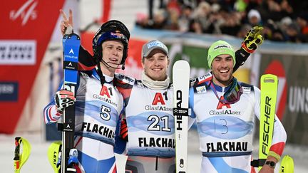 Le podium du slalom de Flachau avec Atle Lie McGrath (au centre), Clément Noël (à gauche) et Daniel Yule, le 9 mars 2022. (BARBARA GINDL / APA / AFP)