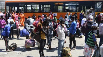 Des travailleurs tentent de quitter Mumbai avec leur famille pour rejoindre leur province d'origine le 29 mars 2020 alors que le gouvernement indien a imposé un lock out national pour lutter contre l'épidémie de coronavirus. (SAJJAD HUSSAIN / AFP)