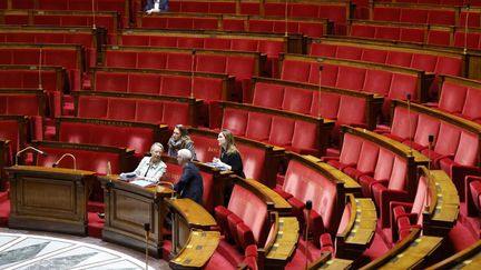 La Première ministre, Elisabeth Borne, discute avec Franck Riester, ministre chargé des Relations avec le Parlement, à l'Assemblée nationale le 4 décembre 2023. (LUDOVIC MARIN / AFP)