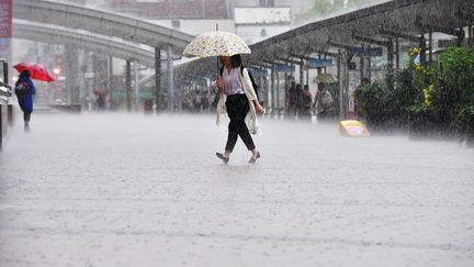 Une passante affronte les intempéries à Kagoshima (Japon), le 3 juillet 2019. Cette ville de près de 600 000 habitants fait partie des zones concernées par l'ordre d'évacuation. (SHOHEI IZUMI / YOMIURI / AFP)