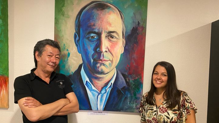 Bernard Martin, Nancy Jolly, militants de la CFDT, posent devant un portrait du secrétaire général du syndicat Laurent Berger, en juin 2023. (LAURIANE DELANOË / RADIO FRANCE)