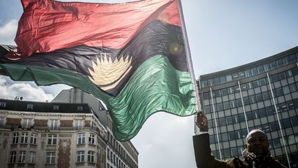 Un homme brandit le drapeau du Biafra en signe de revendication, devant le siège de l'Union européenne, à Bruxelles. (WIKTOR DABKOWSKI / DPA)