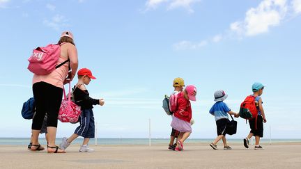 Une animatrice de colonie de vacance avec des enfants, le 25 juillet 2013, sur la plage de Bray-Dunes (Nord). (PHILIPPE HUGUEN / AFP)