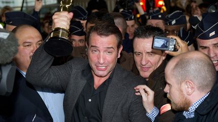 Jean Dujardin se frayant un chemin &agrave; l'a&eacute;roport de Roissy, au lendemain du triomphe du film "The Artist" aux oscars, le 28 f&eacute;vrier 2012. (MARTIN BUREAU / AFP)