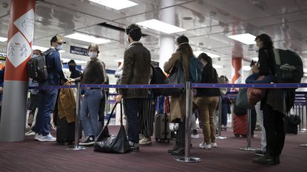 Des passagers patientent dans une file avant le contrôle de leur passeport à l'aéroport Roissy-Charles-de-Gaulle, près de Paris, le 25 avril 2021. (IAN LANGSDON / AFP)