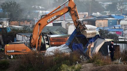 Un engin de chantier déblaie des cabanes, dans la "jungle" de Calais, le 27 octobre 2016. (PHILIPPE HUGUEN / AFP)