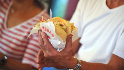 Un vendeur tient un kebab avec des frites. Photo d'illustration. (FRANK PERRY / AFP)