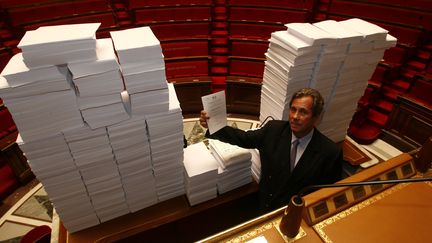 Jean-Louis Debr&eacute;, alors pr&eacute;sident UMP de l'Assembl&eacute;e nationale, pose devant 137 665 amendements contre le projet de loi sur la fusion GDF-Suez, le 5 septembre 2006. (OLIVIER LEJEUNE / MAXPPP)