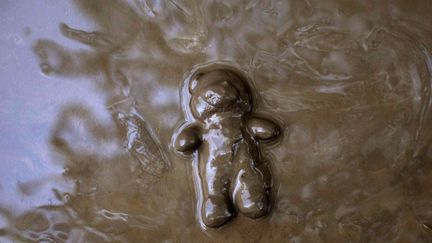 Un ourson en peluche tra&icirc;ne dans la boue apr&egrave;s le passage de l'ouragan Isaac &agrave; Port-au-Prince (Ha&iuml;ti), le 26 ao&ucirc;t 2012. (DIEU NALIO CHERY / AP / SIPA)